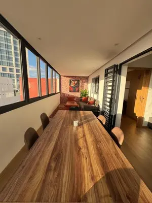 a large wooden table in a room with a couch at Stylish loft with view and terrace Maarif Gauthier in Casablanca