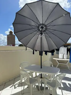a table and chairs with an umbrella on a roof at Signorina appartamento in Temara