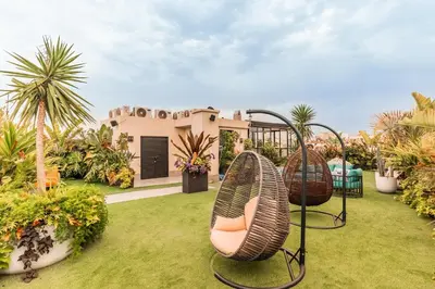 a garden with two chairs and a house at Le Claridge - Cosy Studio - By Mi-Haven in Casablanca