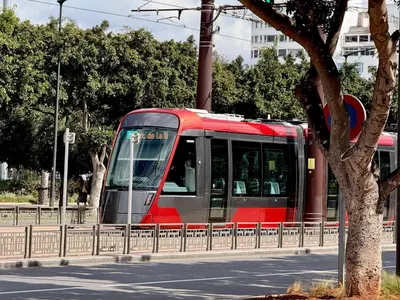 a red and gray train traveling down a street at Le Claridge - Cosy Studio - By Mi-Haven in Casablanca