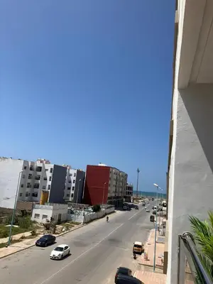 a view of a city street with cars on the road at Appartement lumineux près de la plage de Sidi Bouzid in El Jadida