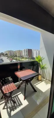a table and a chair on a balcony at Appartement lumineux près de la plage de Sidi Bouzid in El Jadida