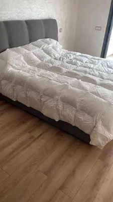 a bed in a bedroom with a wooden floor at Appartement Ferme Bretonne en face de l'OCP - 2 Min CFC in Casablanca