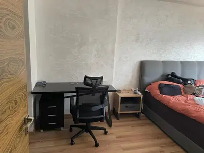 a bedroom with a desk and a bed and a desk and chair at Appartement Ferme Bretonne en face de l'OCP - 2 Min CFC in Casablanca