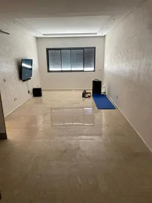 a large empty room with a television and a floor at Appartement Ferme Bretonne en face de l'OCP - 2 Min CFC in Casablanca