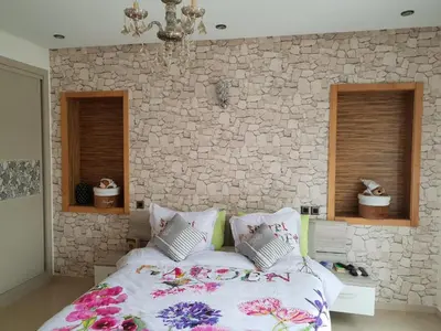 a bedroom with a bed and a stone wall at Villa Blanca - by Nero in Sidi Rahal