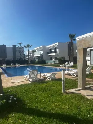 a swimming pool with lounge chairs in front of a building at Villa Blanca - by Nero in Sidi Rahal