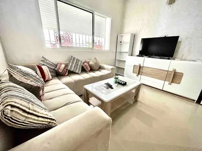 a living room with a couch and a tv at Vivez le Confort Moderne et la Serennité in Rabat