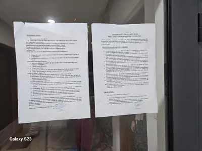 two pieces of paper on a glass window at Appartement Harhoura La vallée pas loin de Arzana hotel in Temara