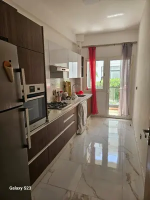 a kitchen with a large white tiled floor at Appartement Harhoura La vallée pas loin de Arzana hotel in Temara