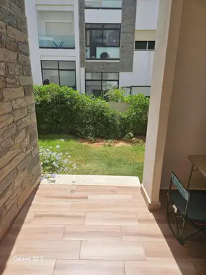 a patio with a chair and a building at Appartement Harhoura La vallée pas loin de Arzana hotel in Temara