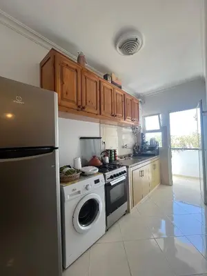 a kitchen with a stove and a washer and dryer at Appartement Skhirat , vue sur mer in Skhirat