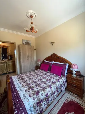 a bedroom with a large bed with pink pillows at Appartement Skhirat , vue sur mer in Skhirat