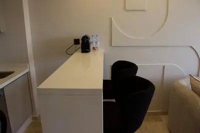 a room with a white counter and black chairs at Chic & central in Maarif