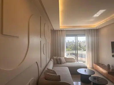 a living room with a couch and a large window at Chic & central in Maarif