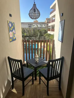 a small table and two chairs on a balcony at Évasion luxueuse avec piscine proche de la mer in Mohammedia