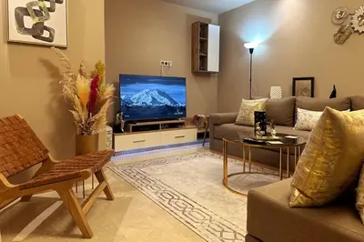 a living room with a couch and a flat screen tv at Évasion luxueuse avec piscine proche de la mer in Mohammedia