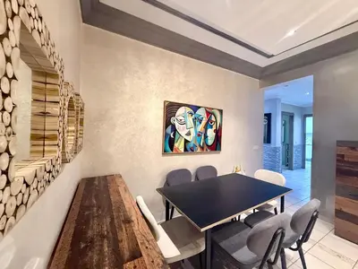 a dining room with a table and a painting on the wall at Apartment Majorelle Garden in Casablanca