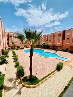a courtyard with two swimming pools and a palm tree at logement entier familly house in Tamaris