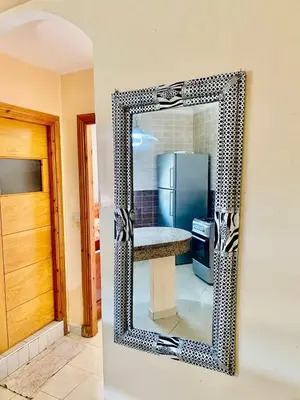a mirror on the wall of a kitchen with a refrigerator at logement entier familly house in Tamaris
