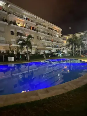 a large swimming pool in front of a building at night at Les jardins de bouznika in Bouznika