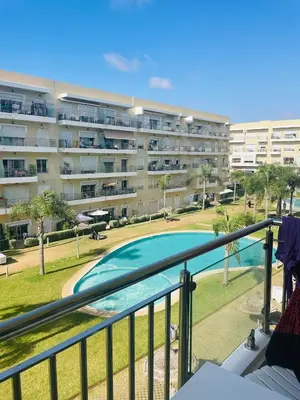 a balcony with a swimming pool and a building at Les jardins de bouznika in Bouznika