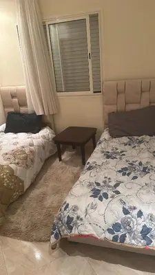 a bedroom with two beds and a table at Les jardins de bouznika in Bouznika
