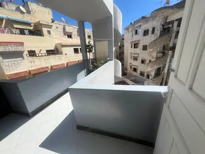a white balcony with a view of a building at Spacieux appartement proche de la mer in Casablanca