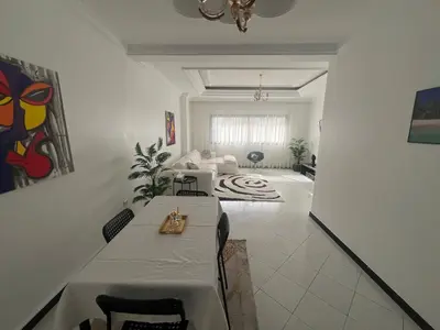 a room with a table and a living room at Spacieux appartement proche de la mer in Casablanca