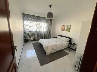 a bedroom with a bed and a window at Spacieux appartement proche de la mer in Casablanca