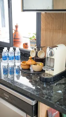 a kitchen counter with bottles of water and a toaster at Nafhat al arz - Moroccan and refined in Mohammedia