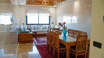 a living room with a table with chairs and a couch at Nafhat al arz - Moroccan and refined in Mohammedia