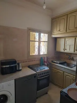 a kitchen with a stove and a sink and a window at Dar Isa in Sidi Rahal