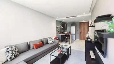 a living room with a gray couch and a kitchen at Studio Cosy les Princesses in Casablanca