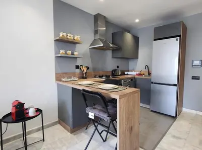 a kitchen with a counter and a stove and a refrigerator at Studio Cosy les Princesses in Casablanca