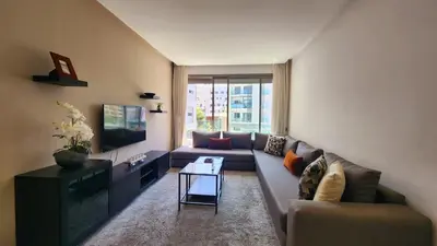 a living room with a couch and a tv at Studio Cosy les Princesses in Casablanca