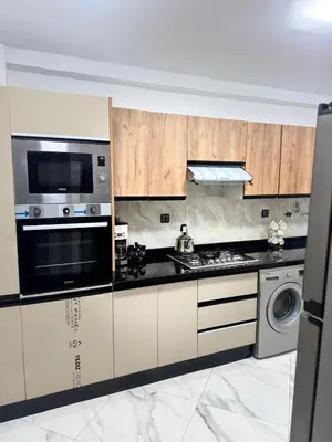 a kitchen with wooden cabinets and a stove top oven at résidence Amina in Rabat