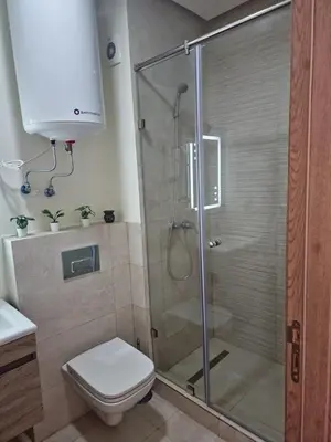 a bathroom with a shower with a toilet and a sink at Studio Zen vue sur mer in Aïn Harrouda