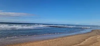 a sandy beach with waves in the ocean at Studio Zen vue sur mer in Aïn Harrouda