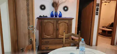 a room with a wooden cabinet with blue vases on it at appartement el Mansouria Sable d'or in O Ben Slimane