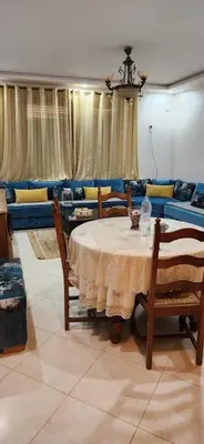 a living room with a table and a couch at appartement el Mansouria Sable d'or in O Ben Slimane