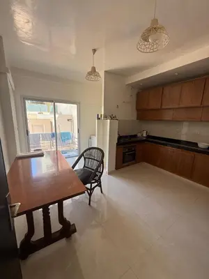 a kitchen with a wooden table and a chair in it at Appartement central familial avec grande terrasse in Casablanca