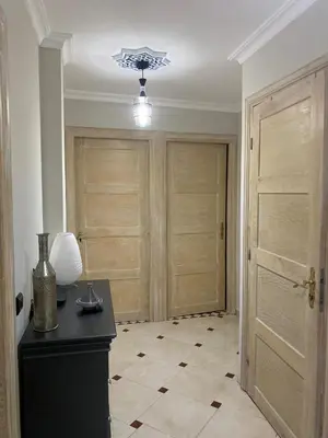a room with two doors and a table with a lamp at Appartement location saisonnière Mohammedia in Mohammedia