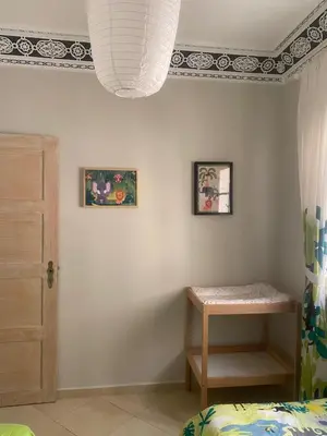 a bedroom with a bed and a table and a ceiling at Appartement location saisonnière Mohammedia in Mohammedia
