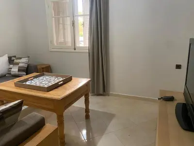 a living room with a table and a couch at Appartement location saisonnière Mohammedia in Mohammedia