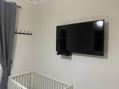a flat screen tv hanging on a white wall at Appartement location saisonnière Mohammedia in Mohammedia