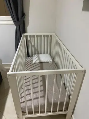 a white crib with a pillow in a room at Appartement location saisonnière Mohammedia in Mohammedia