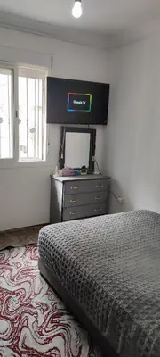 a bedroom with a bed and a dresser with a television at Calme absolu in Aïn Harrouda