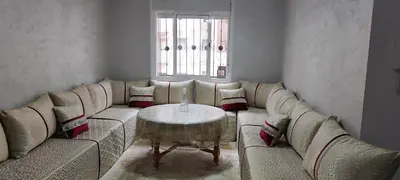 a living room with a couch and a table at Calme absolu in Aïn Harrouda