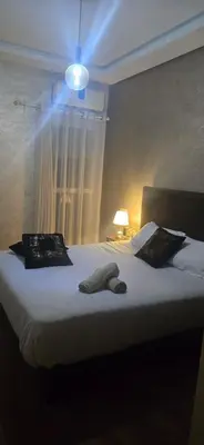 a bedroom with a large bed with a light on it at Appartement Flora Nora in Casablanca